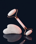 Jade roller and gua sha set on navy studio background